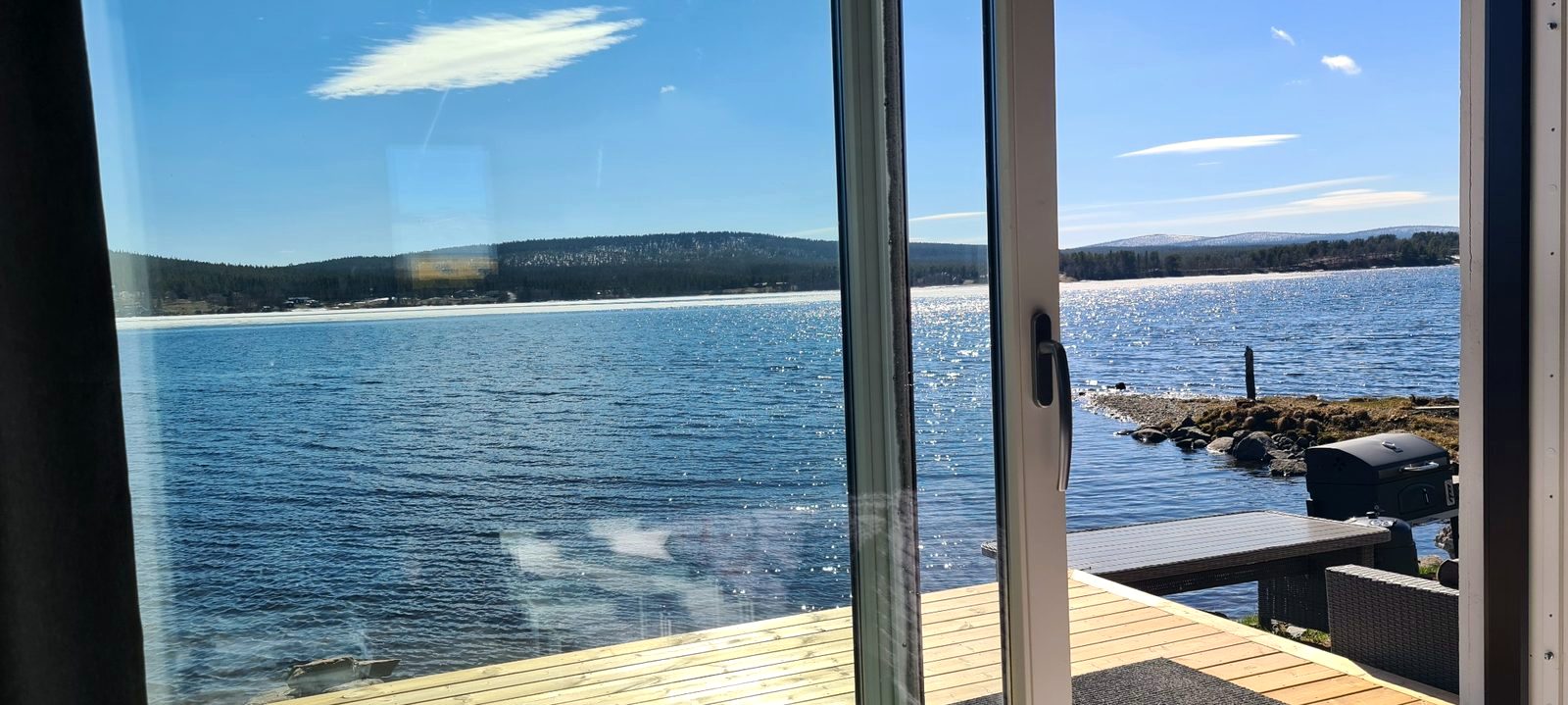 Blick von der Hütte am Wasser über den See in Jukkasjärvi
