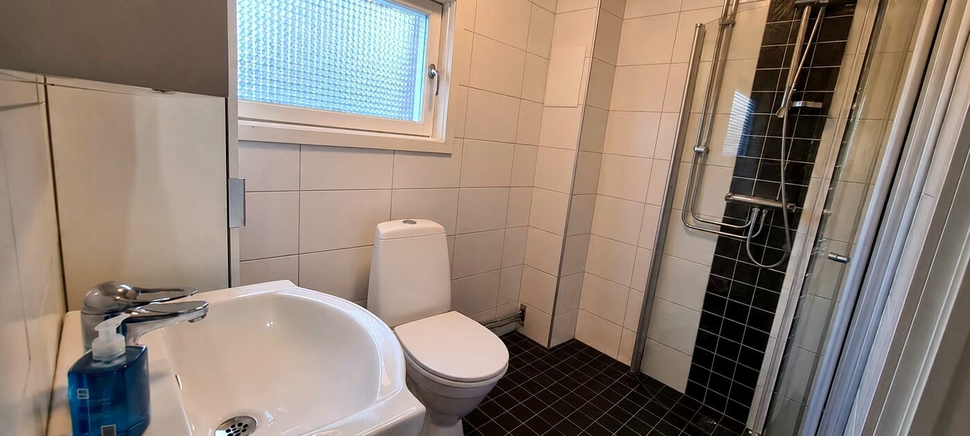 Modernt badrum med dusch i möblerat företagsboende
